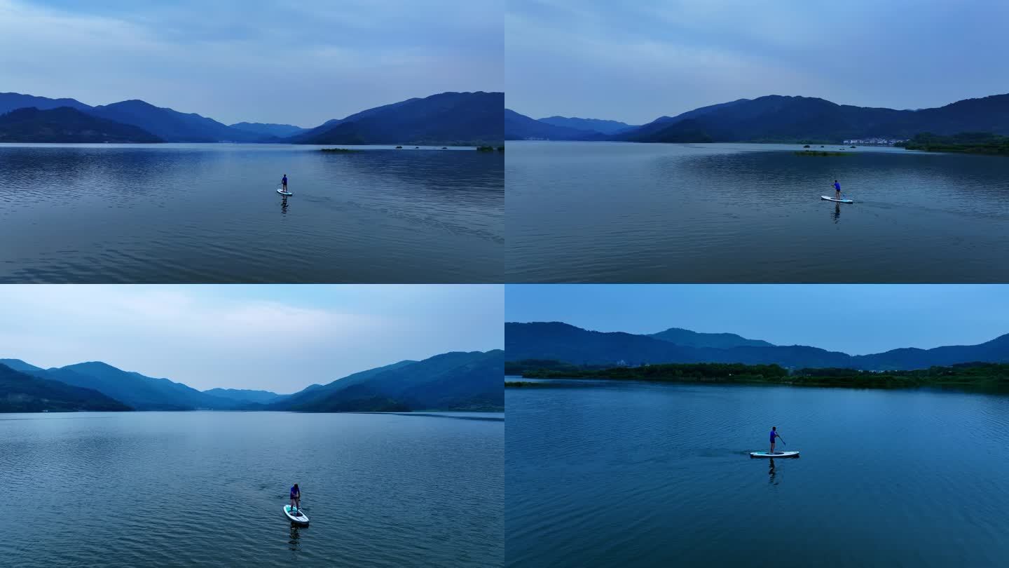 一个男人在湖里划SUP、浆板