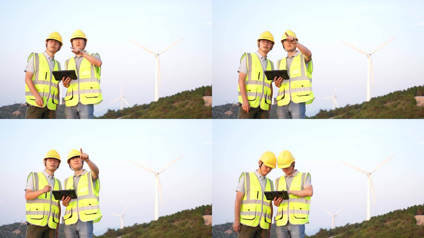 夕阳下工程师在风力发电风电场工作沟通