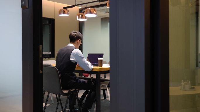 商务人士在会议室边喝咖啡边使用电脑