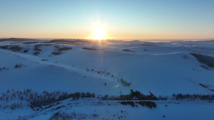 阳光积雪覆盖的山坡逆光航拍