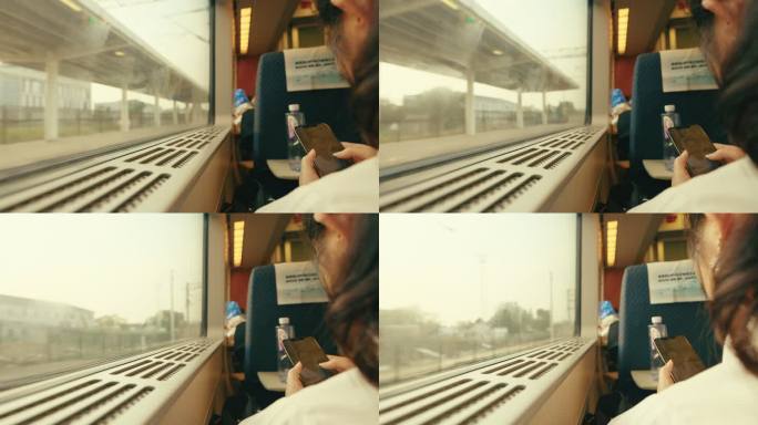 高铁车厢里靠窗玩手机的女人