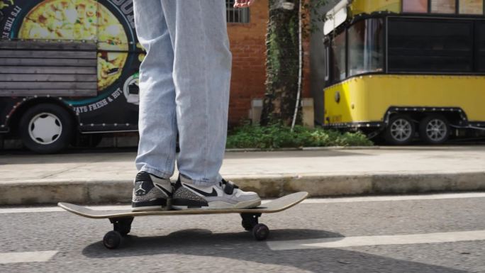 青少年在潮玩社区玩滑板的背影