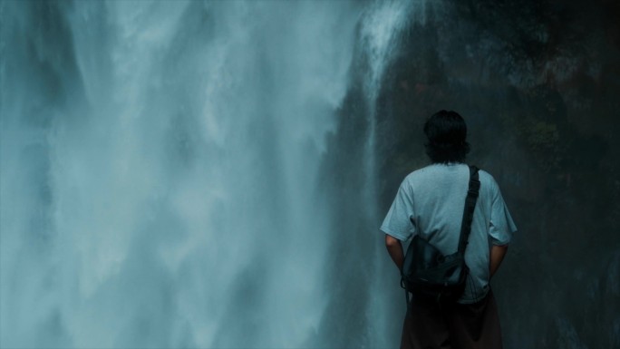 旅游爱好者户外徒步男人站在瀑布前思考未来