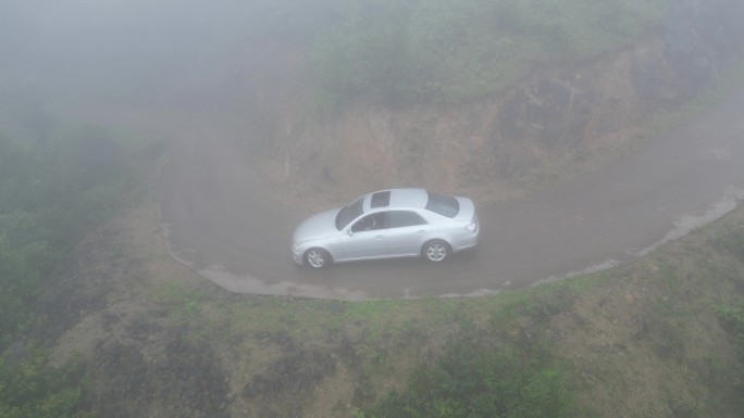 俯瞰林间穿过迷雾的车辆