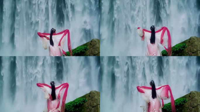 女生站在瀑布前张开双臂拥抱瀑布裙子飞扬