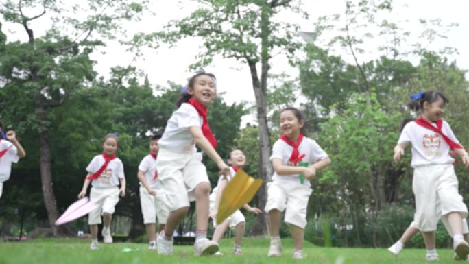 小学生在公园扔纸飞机