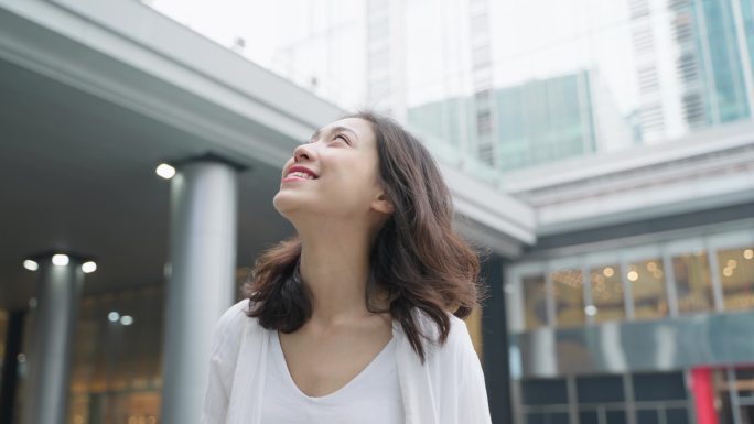 阳光开心美女走在城市街头欣赏都市风景