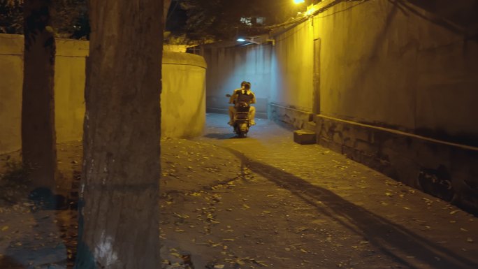 夜晚巷子里路过的摩托车