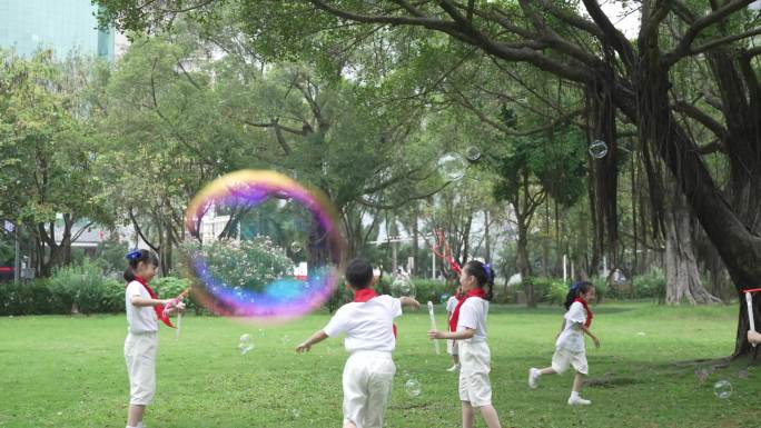 小学生在公园吹泡泡追逐玩耍打闹