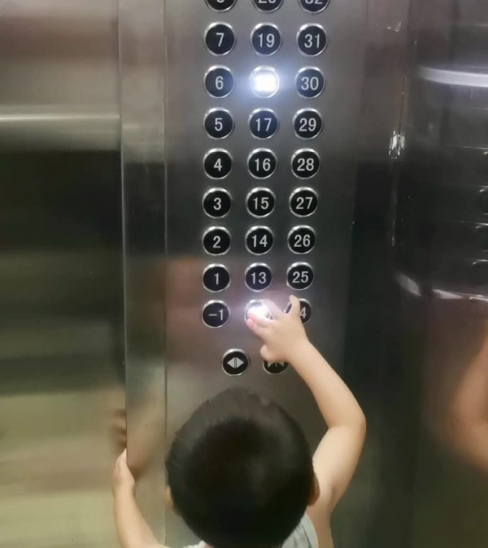 淘气小男孩按电梯键-从小教育