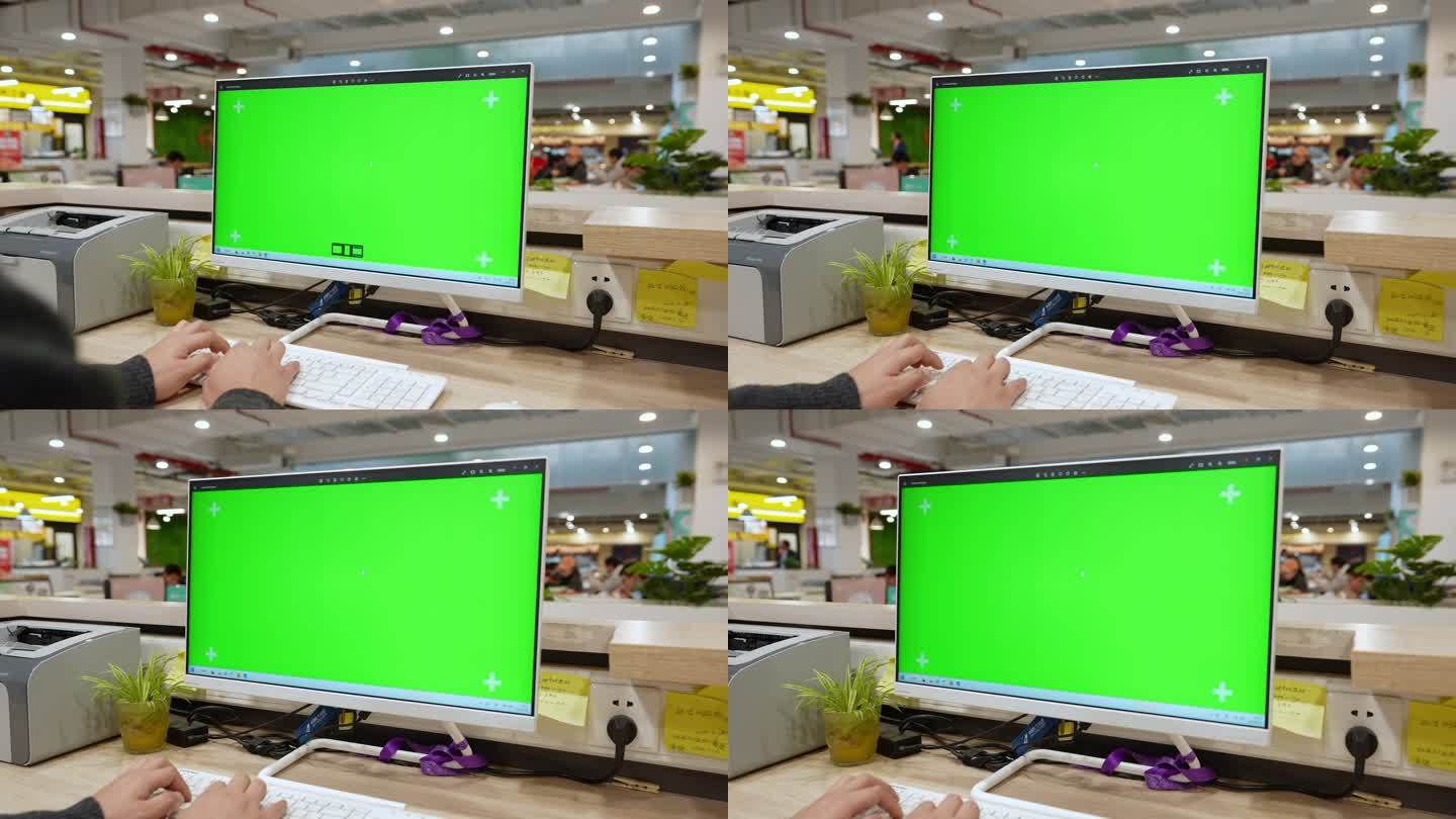男子在绿色屏幕的电脑前办公