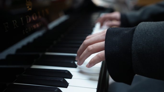 钢琴家在室内弹奏钢琴的手的特写