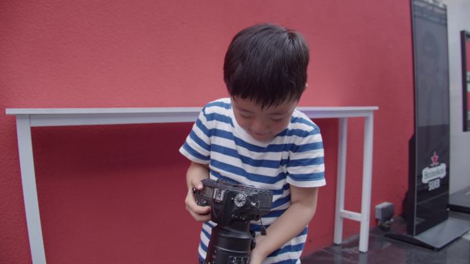 小孩使用单反相机拍照