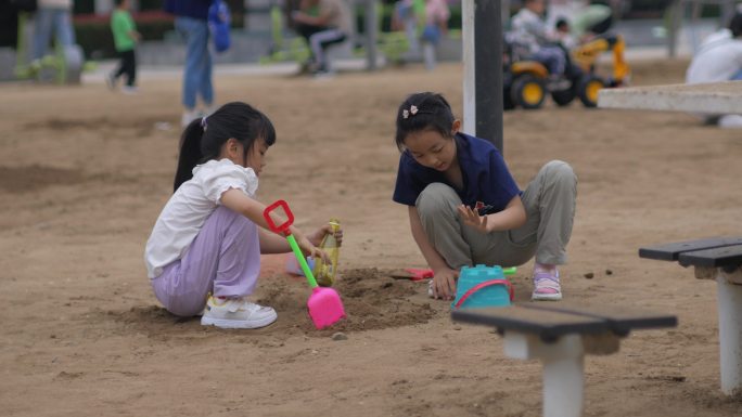 两个小女孩在沙滩玩沙子