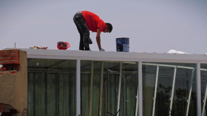 油漆工人烈日粉刷屋顶