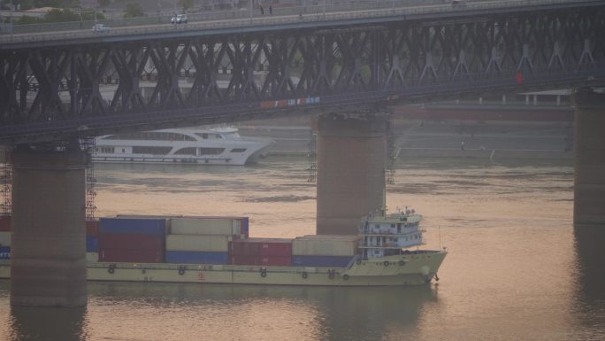 武汉市长江大桥下清晨日出通过的运输船