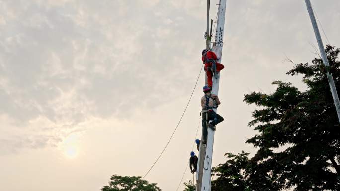 电力工人在夕阳下建设电力工程