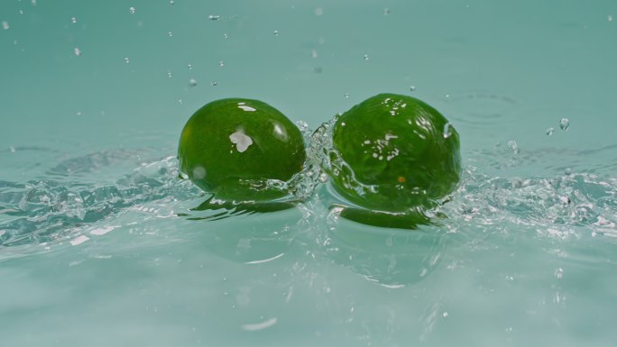 一对柠檬在水面碰撞高速特写柠檬青柠檬