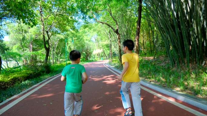 两个小孩在公园跑道跑 林荫小路 向前冲
