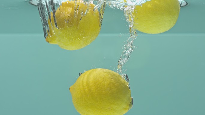 三个柠檬掉入水中特写柠檬黄柠檬