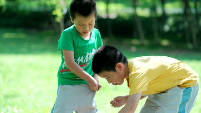 两个小孩在树林里捉虫子 玩蚱蜢 蝗虫