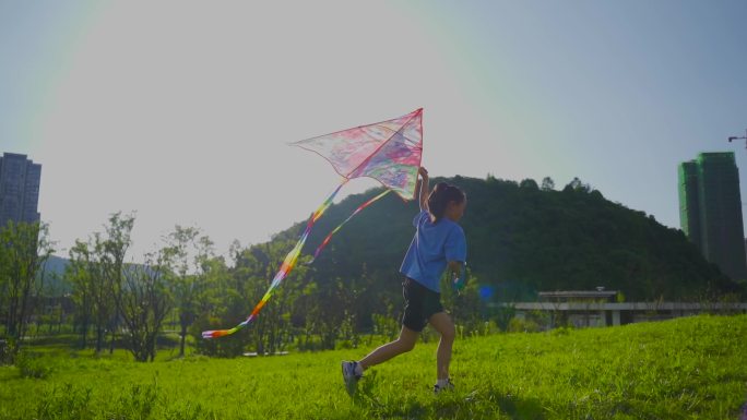 美丽的小女孩在公园草地奔跑放风筝特写