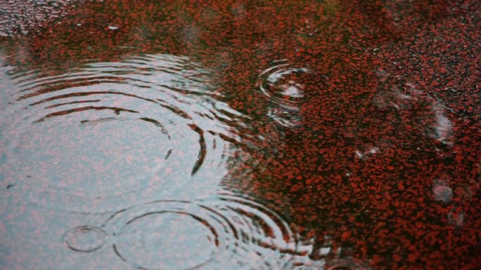 下雨天路面积水雨滴打在地面上水花