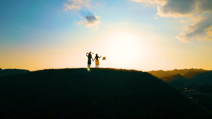 一家三口黄昏看夕阳幸福人日落时分山顶散步