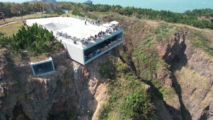 航拍俯瞰夏季的山东荣成鸡鸣岛悬崖咖啡厅