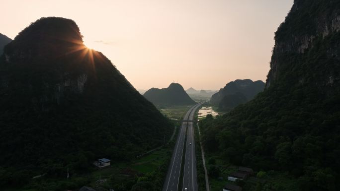 黄昏日落喀斯特山谷中穿行的高速公路