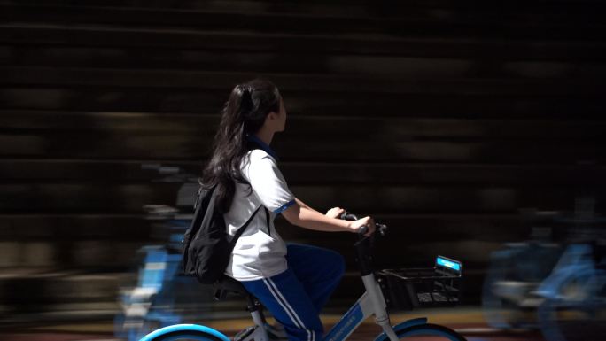 晚上下课后放学女学生骑自行车背影青春时代