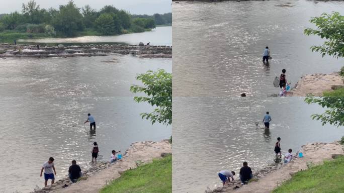 枯水期浅水区捞鱼游玩河边戏水的人