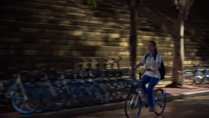 晚上下课后放学女学生骑自行车背影青春时代