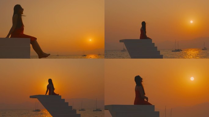 高台上夕阳下海边海风中看日落的女孩