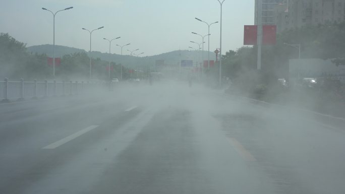 夏天洒水车驶过后马路上的水汽