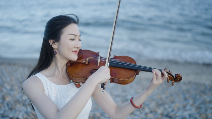 美女海边拉小提琴