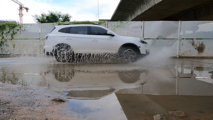 雨后路面积水汽车轧过泥水坑水花飞溅