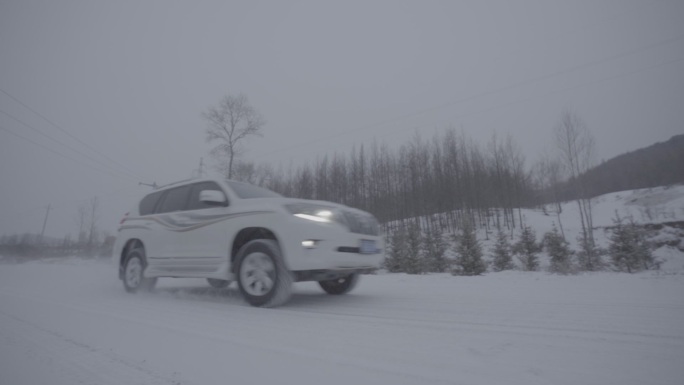 下雪天丰田汽车驶过雪地公路近景仰拍
