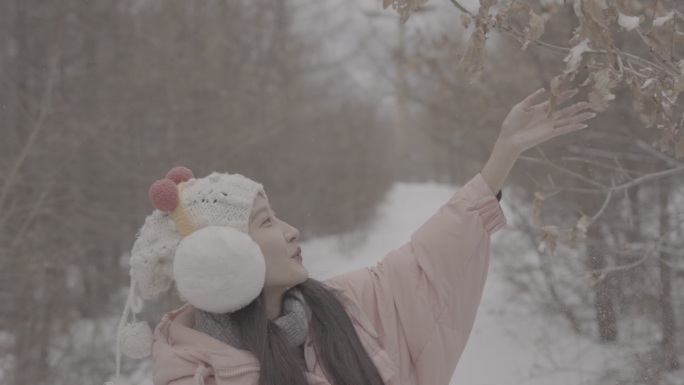 山林雪地羽绒服美女触碰树叶