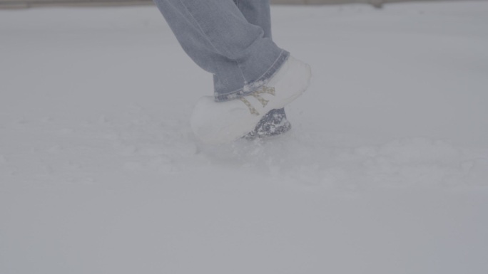 雪中牛仔裤美女踩雪前行特写