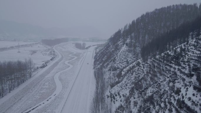 航拍山间林地雪地公路汽车行使1