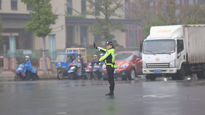 雨天城市道路女交警警察马路中间指挥交通