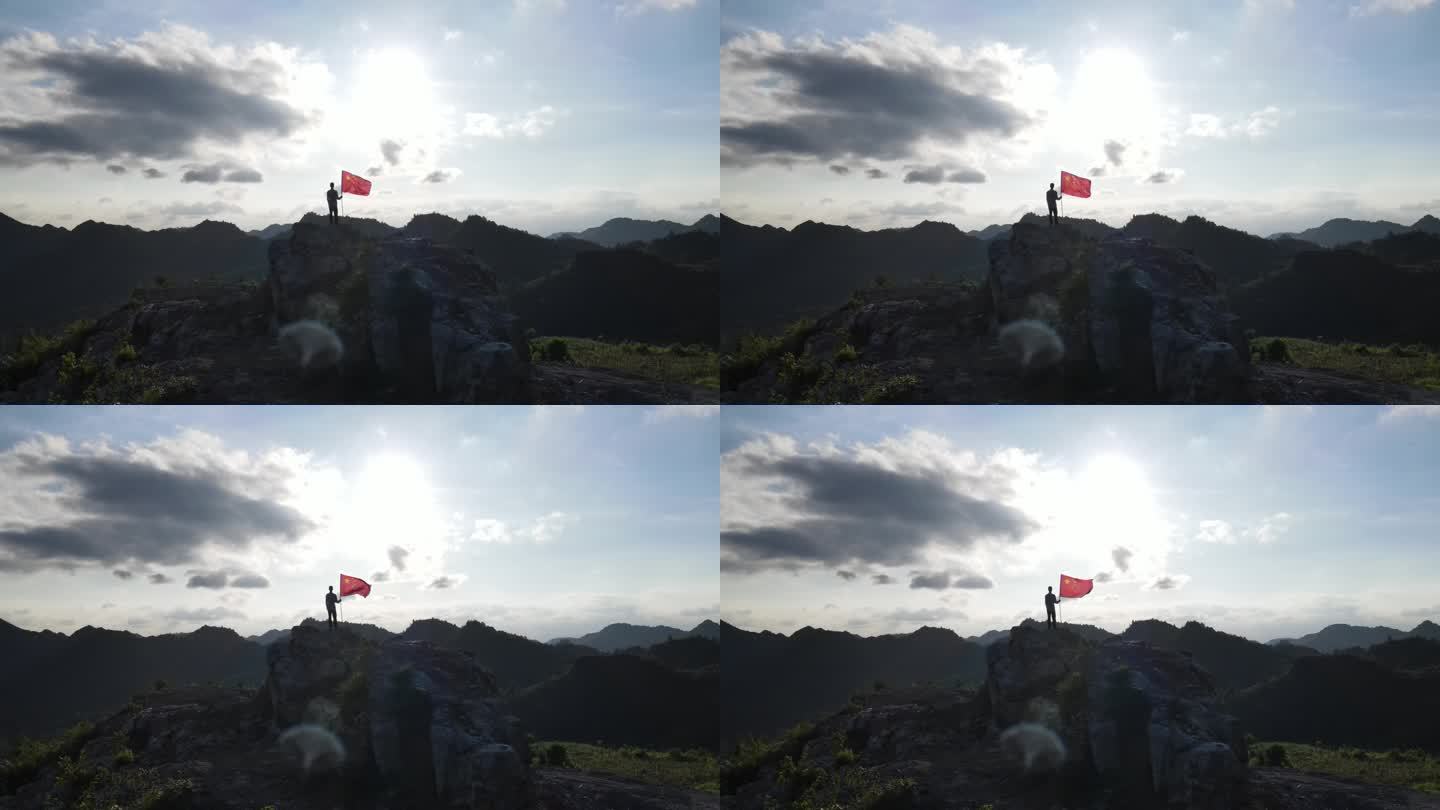 航拍少年手持红旗站在山顶眺望远方国旗飘扬