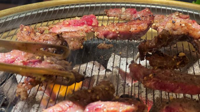 在韩国烤肉店堂食，炭火炉上烤肉