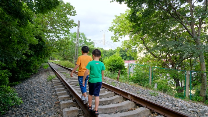 两个小孩走在铁路上