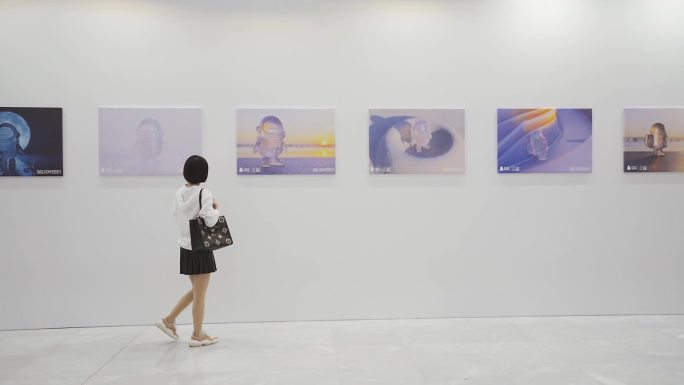 美女拿相机参观画展、艺术展