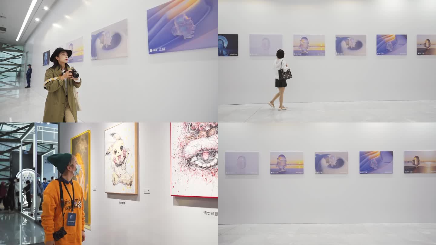 美女拿相机参观画展、艺术展