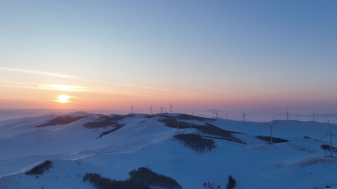 雪原山岭和风力发电场日落