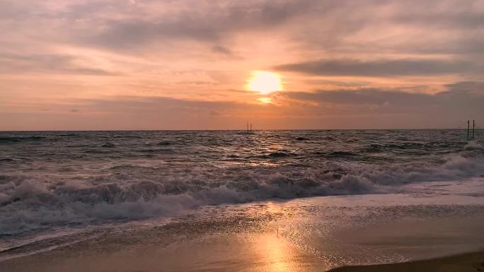 日落黄昏夕阳下的海滩灯塔海浪拍打礁石
