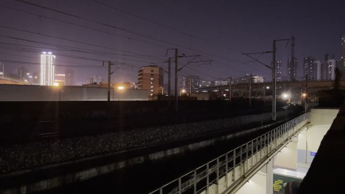 城市中夜幕下快速行驶过的动车高铁